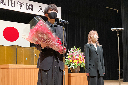 織田ファッション専門学校の新入生へ花束を贈っている先輩学生