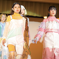 織田ファッション専門学校のファッションショーで黄と水の衣装を着てランウェイを歩く学生たち