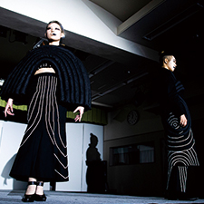 織田ファッション専門学校のファッションショーで黒い衣装を着てランウェイを歩く学生たち