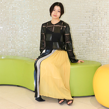ロビーの椅子に座る織田ファッション専門学校ファッションテクニカル科学生