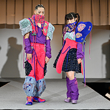 織田ファッション専門学校のファッションショーでピンクの衣装を着てランウェイを歩く学生