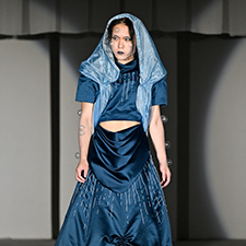 織田ファッション専門学校のファッションショーで紺の衣装を着てランウェイを歩く学生