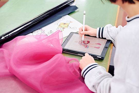 iPadでファッションデザイン画を描く織田ファッション専門学校ファッションデザイン科の学生