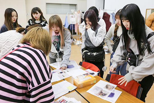 ファッション誌の撮影現場でイメージを確認する織田ファッション専門学校のスタイリスト科の学生たち