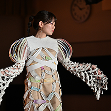 織田ファッション専門学校のファッションショーで白い衣装を着てランウェイを歩く学生