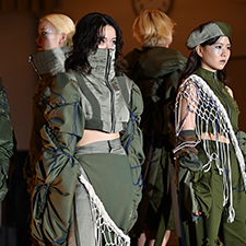 織田ファッション専門学校のファッションショーで緑の衣装を着てランウェイを歩く学生