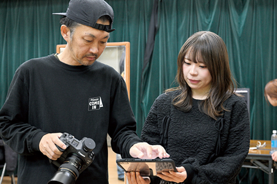 撮影現場でフォトグラファーと相談をする織田ファッション専門学校スタイリスト学生