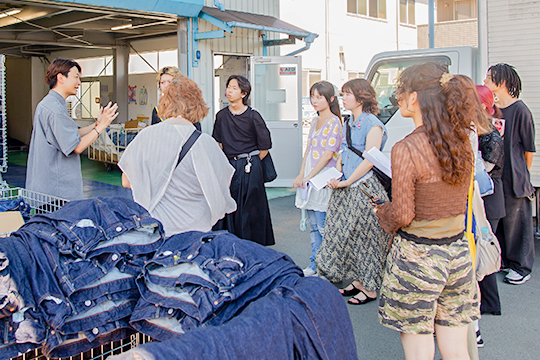 デニム加工の説明を受ける織田ファッション専門学校ファッションデザイン専攻科とファッションテクニカル専攻科の学生