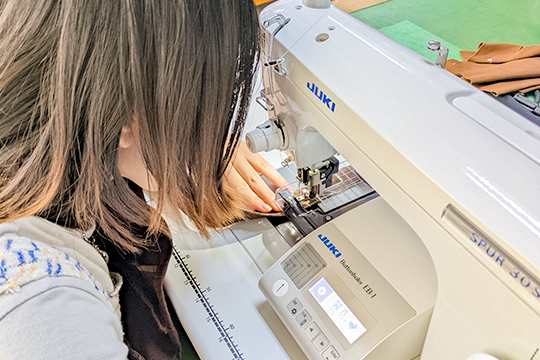 ポップアップストア用の商品をミシンで縫製する織田ファッション専門学校学生