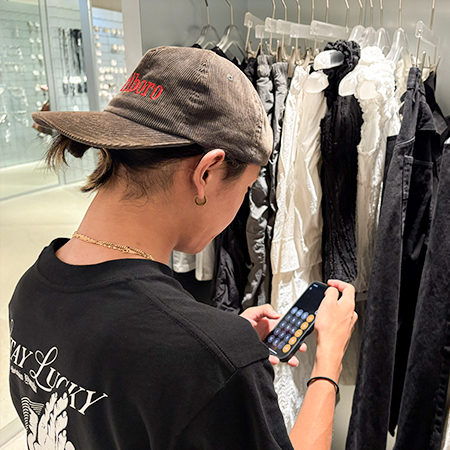 スマートフォンでコストを計算する織田ファッション専門学校マーチャンダイジング研究科学生